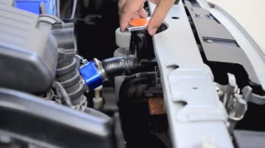 Araba temiz ve radyatör kapağı açmak için mavi mikro fiber kumaş kullanarak adamın elini