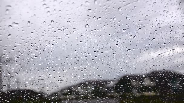 Cielo nublado de lluvia con lluvia cayó de la ventana del coche vista de cristal desde la ventana cerca del pueblo — Vídeos de Stock