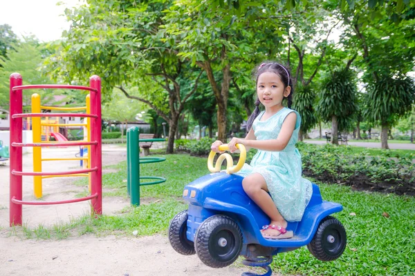 Bonito ásia tailandês pouco menina sentado no o brinquedo carro no jogar groun — Fotografia de Stock