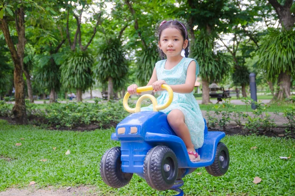 Bonito ásia tailandês pouco menina sentado no o brinquedo carro no jogar groun — Fotografia de Stock