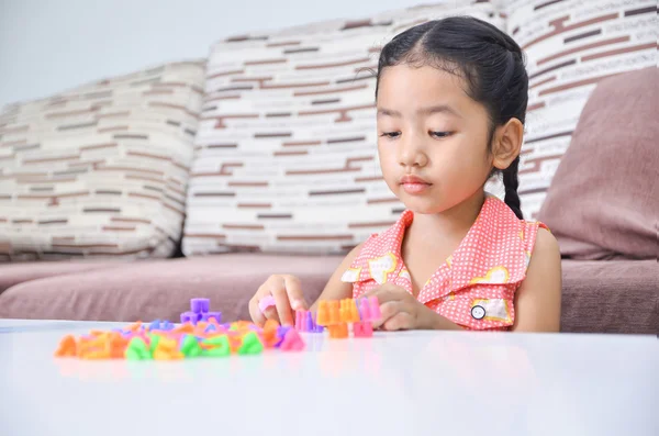 ホムでテーブルの上でレンガを遊ぶかわいいアジアの小さな女の子の肖像画 — ストック写真