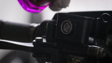 Yakın çekim mekanikeri ön fren tankına fren yağı döküyor motosiklet, seçici odak derinliği alan derinliği