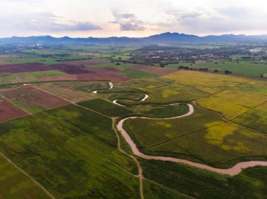 Nehir ve havzanın doğal bir dağa karşı manzaralı manzarası, Drone gürültülü ve tahıl işlenmiş tropikal araziyi vurdu.