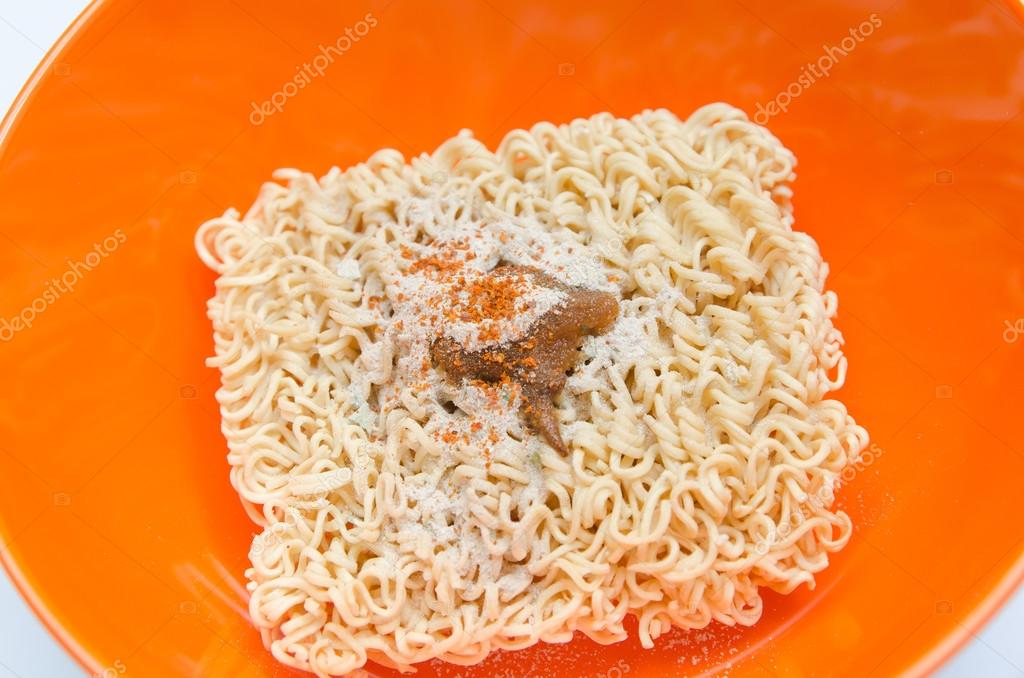 Nouille instantanée sèche dans un bol orange sur fond blanc image