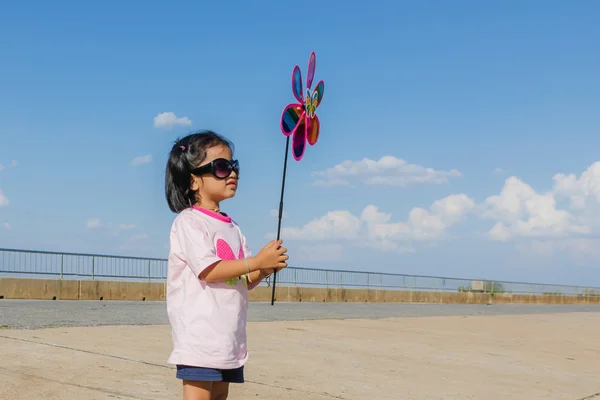 Asiático menina com turbina eólica brinquedo em mãos — Fotografia de Stock