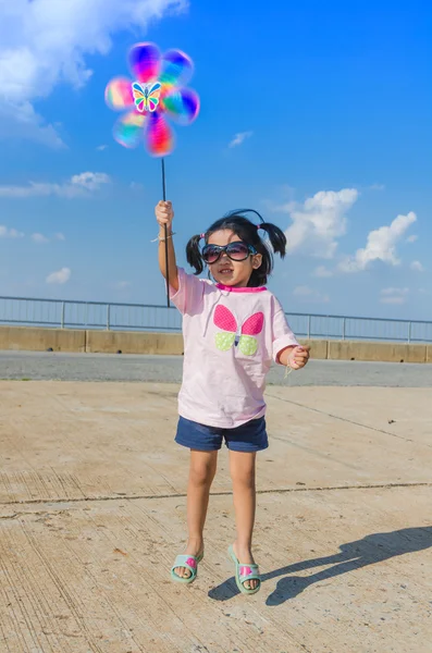 Asiático menina com turbina eólica brinquedo em mãos — Fotografia de Stock