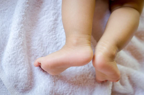 Fechar os pés do bebê em tecido branco — Fotografia de Stock
