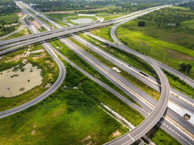 Drone, Tayland 'da yeşil tarlaların üzerinden geçen büyük bir otoyol kavşağını vurdu. Katmanlı yollar ve rampalar kırsal bir yerdeki modern ulaşım altyapısını vurguluyor