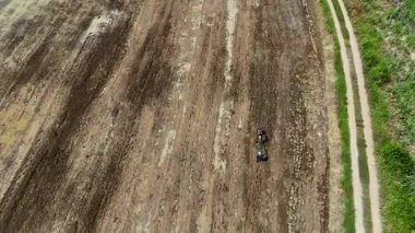Çiftçilerin hava manzarası toprağı sürmek için küçük bir traktör kullanıyor.