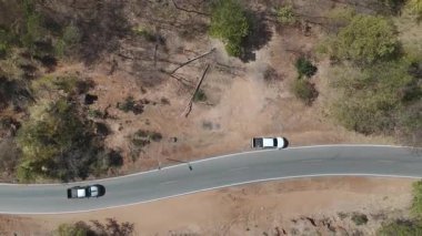 Kırsal bir yolda kırsal araziden geçen bir kamyonetin hava aracı görüntüsü. Doğada seyahat, ulaşım ve özgürlüğün manzaralı görüntüsü