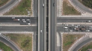 Çevresi yeşil tarım arazisiyle çevrili çok katmanlı yollar ve eğimli rampalarla modern otoyol kavşağının havadan görünüşü, ulaşım altyapısı, kentsel gelişim ve karayolu planlaması sergileniyor.