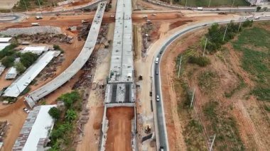 Kırsal kesimdeki bir yol kesişiminde, inşaat mühendisliği, altyapı geliştirme ve ulaşım projelerini gösteren hava aracı görüntüleri