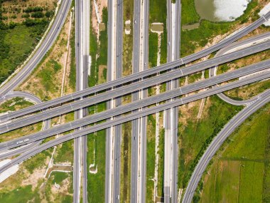 Drone, Tayland 'da yeşil tarlaların üzerinden geçen büyük bir otoyol kavşağını vurdu. Katmanlı yollar ve rampalar kırsal bir yerdeki modern ulaşım altyapısını vurguluyor