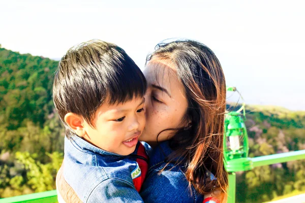 Actividad familiar al aire libre. Alegre joven mamá y pequeño niño pl — Foto de Stock