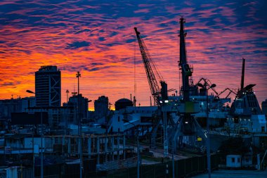 Şehrin arka planında turuncu-mavi gün batımı