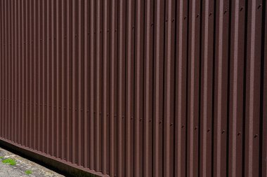 Kahverengi kıvrımlı çit, bina kıvrımlı tahta ile kaplanmış.