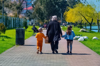 Batumi, Georgia - 7 Nisan 2021: Büyükanne ve torunları parkta yürüyüşe çıktılar