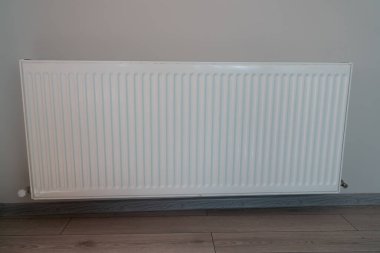 Dairenin duvarında beyaz radyatör var.