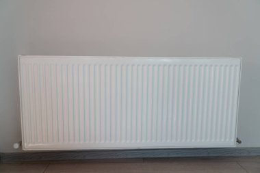 Dairenin duvarında beyaz radyatör var.