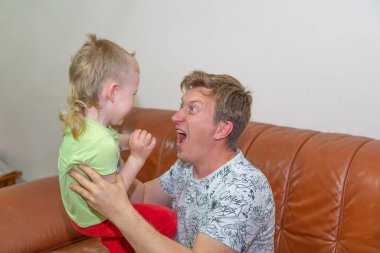 Baba ve oğul kanepede yatarlar.