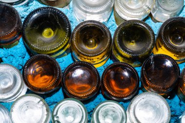 Soyut bir arkaplan olarak beyaz bir duvarda çok renkli şişeler