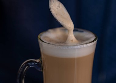 Kahveyi kaşıkla karıştıran adam.