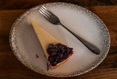 Cheesecake çatallı bir tabakta yatıyor.