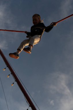 Batumi, Georgia - 8 Mayıs 2021: Lastik bir bandın üzerine atlayan çocuk