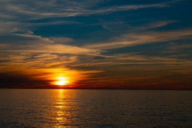 Denizin arka planında sarı gün batımı