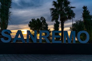 White letters on a yellow sunset background