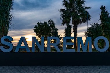 White letters on a yellow sunset background