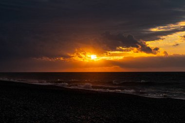 Orange sunset on the background of sea waves