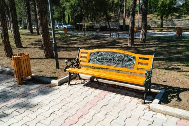 Wooden brown bench and urn in the park