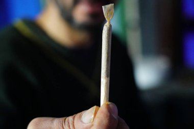 Elinde sigara tutan bir adam.