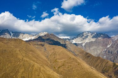 Brown mountain in the clouds view from a drone