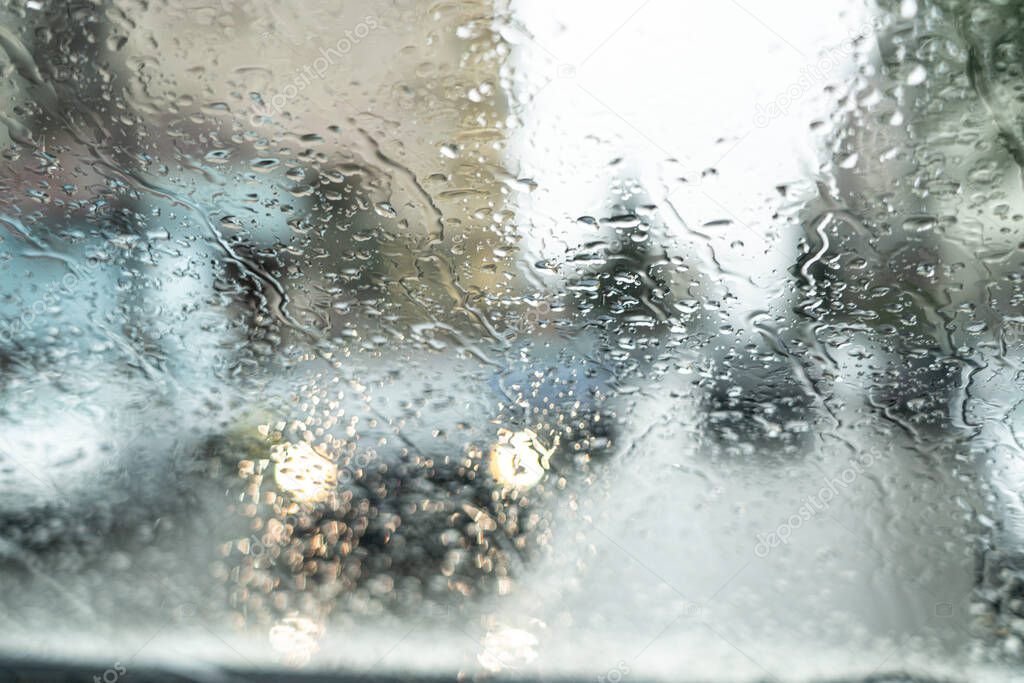 Car lights through glass in raindrops