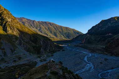 Mavi gökyüzüne karşı yeşil çimenli dağlar
