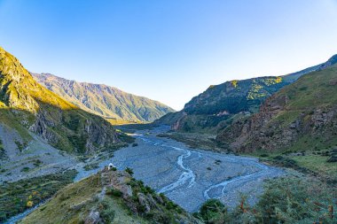 Mavi gökyüzüne karşı yeşil çimenli dağlar