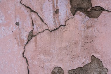 Duvardaki pembe alçı soyut bir arka plan olarak çatlaklarla dolu.