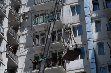 Batumi, Georgia - July 5, 2021: Lifting a load into an apartment using a crane