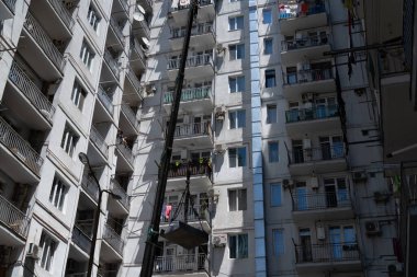 Batumi, Georgia - July 5, 2021: Lifting a load into an apartment using a crane