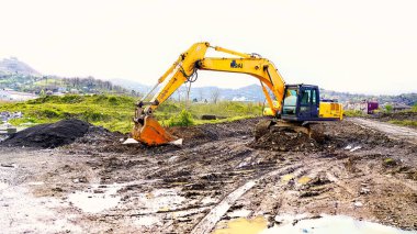 Batumi, Gürcistan - 12 Nisan 2021: Şehrin sanayi bölgesinde çamurun içinde kazı yapan