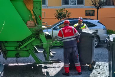 Batumi, Georgia - 7 Nisan 2021: Çöpçüler çöp tenekelerini temizler