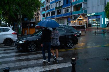 Batumi, Gürcistan - 14 Temmuz 2021: Yağmurda şemsiye altındaki insanlar