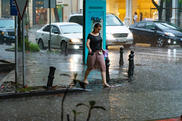 2021年7月14日 佐治亚州巴统 女孩赤脚在雨中沿街行走 — 图库照片