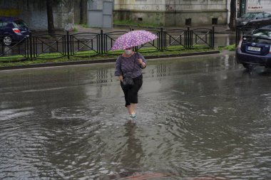 Batumi, Gürcistan - 27 Temmuz 2021: İnsanlar yağmurda sokakta yürüyor