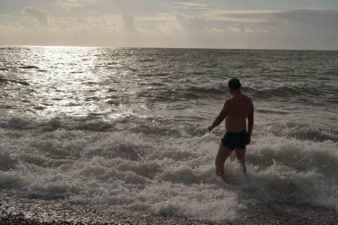 Batumi, Gürcistan - 28 Temmuz 2021: Bir adam fırtınada denizde yüzüyor