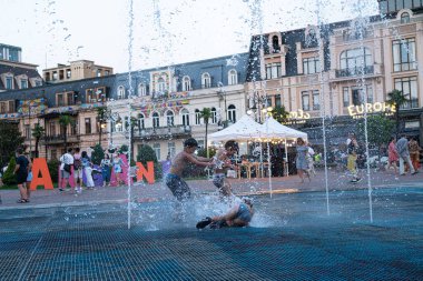 Batumi, Gürcistan - 13 Ağustos 2021: Çocuklar şehir çeşmesinde banyo yapıyor