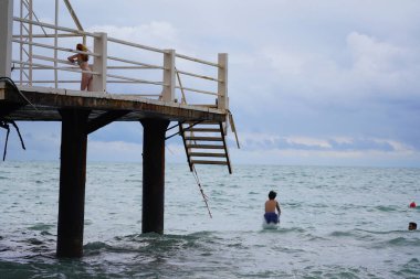 Batumi, Gürcistan - 11 Ağustos 2021: Erkekler iskeleden denize atlıyor