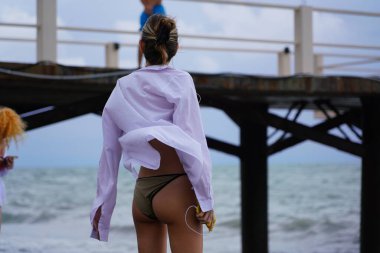 Batumi, Gürcistan - 11 Ağustos 2021: Fırtına sırasında deniz kıyısında bir kız